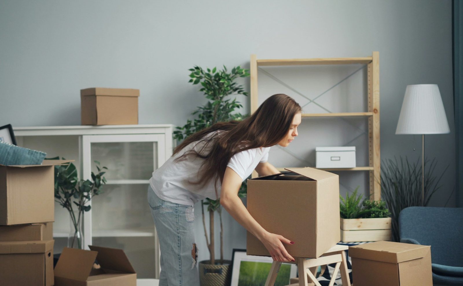 Mujer acomodando cajas de mudanza en un departamento